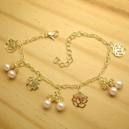 pulseira em metal na cor dourado com pingentes pérola flor